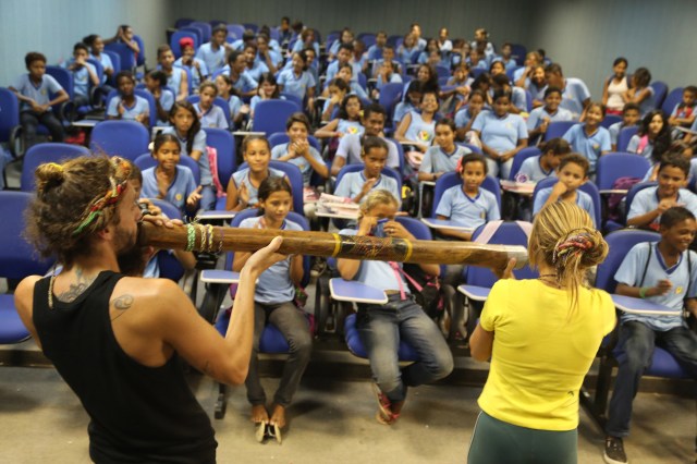 Bobi e Mara toca o digeridoo na escola Judith Gomes Leitão para celebrar a diversidade cultural.