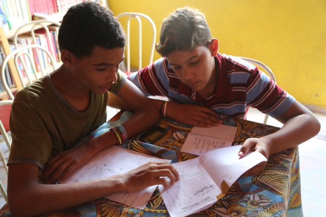 Rafael Varão (coordenador da biblioteca Folhas da Vida) e Matheus Sá (Latinhas de Quintal) estudem o primeiro boneco do novo jornal comunitário Nem Um Pingo que vão  lançar na semana depois do Dia das Mães.