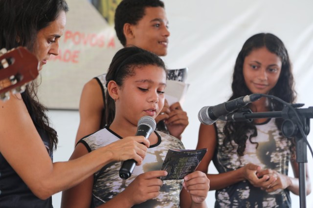 Viviane do projeto Biblioteca Folhas da Vida le o poema Vento Norte na Feira de Sementes Tradicionais.