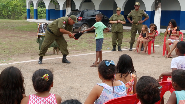 O mágico brinca com crianças e jovens de Cabelo Seco no quartel, criando laços humanos de respeito pelos direitos humanos.